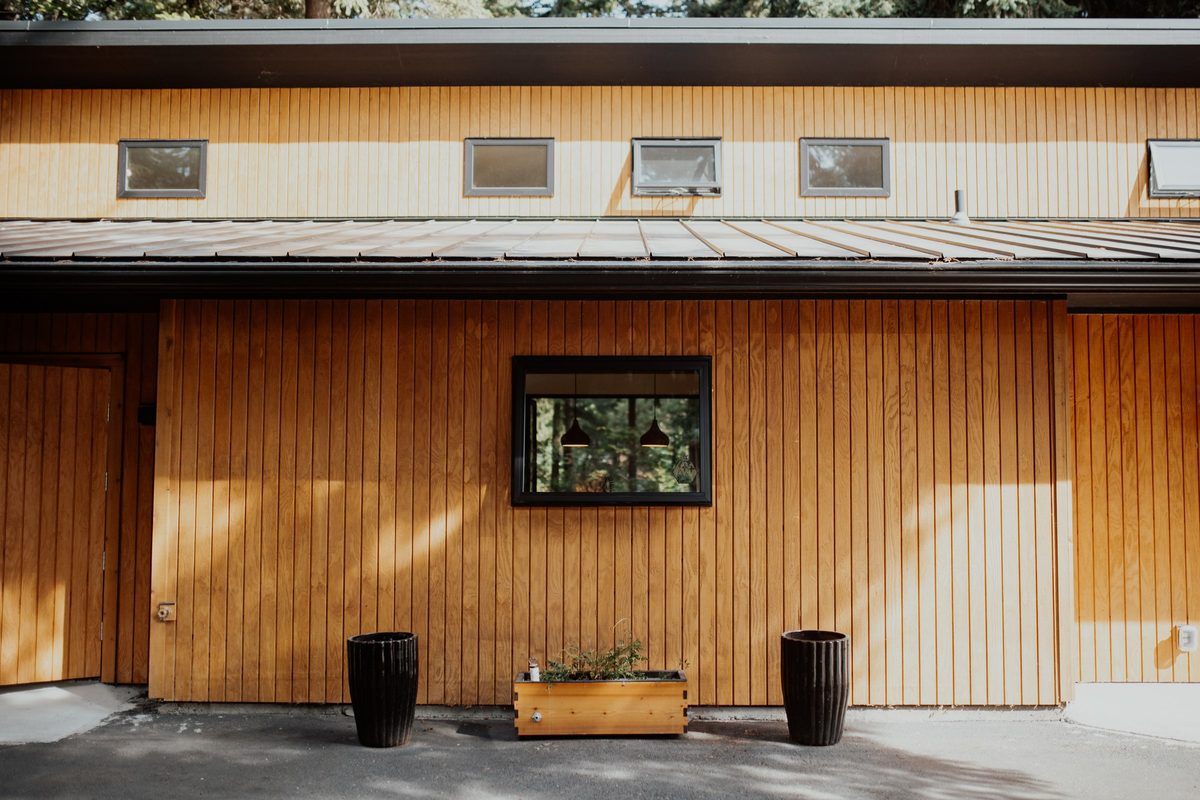 Straight-on view of the cabin's clerestory windows, cedar siding, and planter