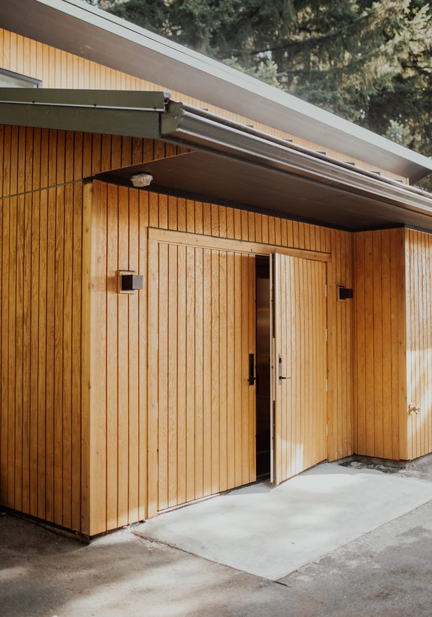 Angled view of the handmade cedar-clad doors beneath the cabin's roof overhang