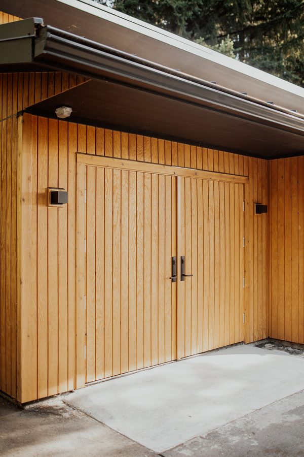 Close angled view of the custom wood doors and surrounding cedar siding