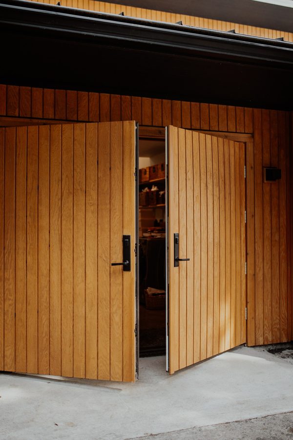Custom cedar-clad wood door partially open into the cabin
