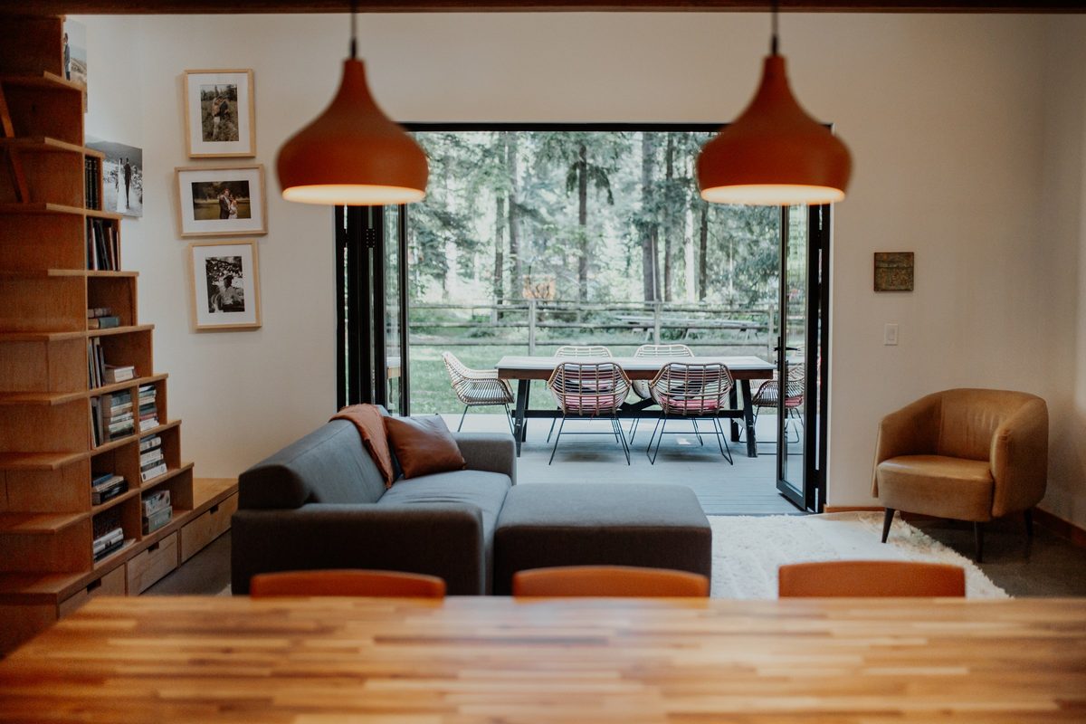 Cabin living area looking through the open doors toward the deck and surrounding woods
