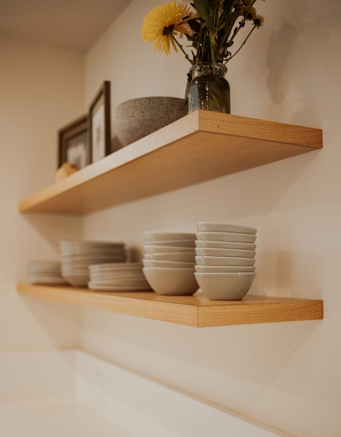 Close view of the cabin's wood floating shelves and their finished edges