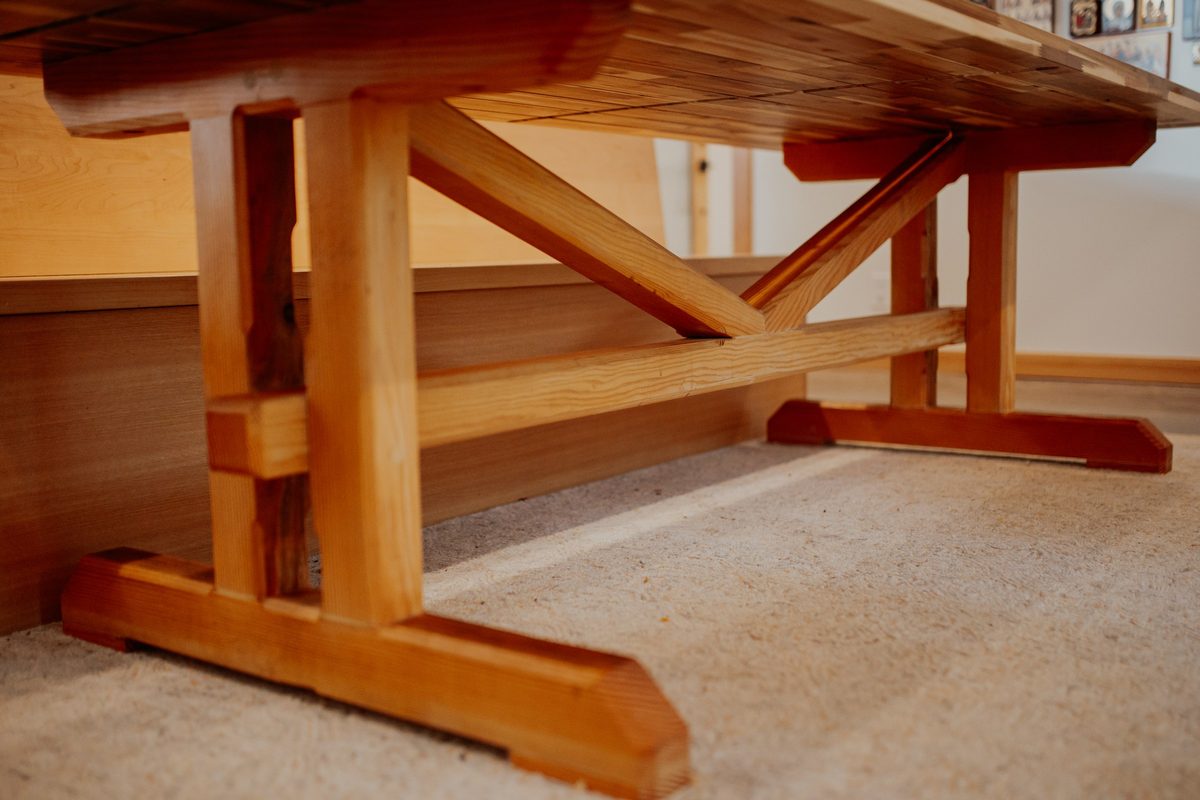 Joinery and trestle base beneath the handmade wood dining table