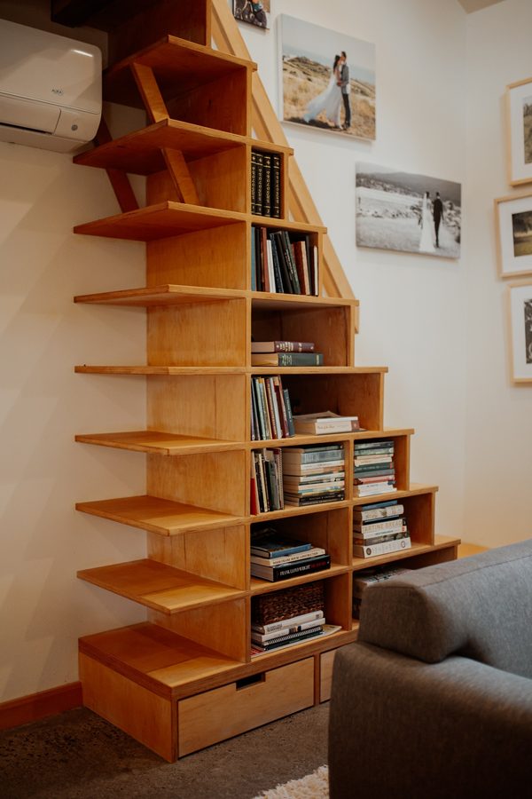 Custom wood bookcase staircase leading from the living area to the loft