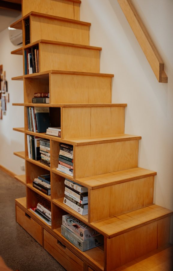 Front view of the custom wood staircase, deep treads, and integrated shelving