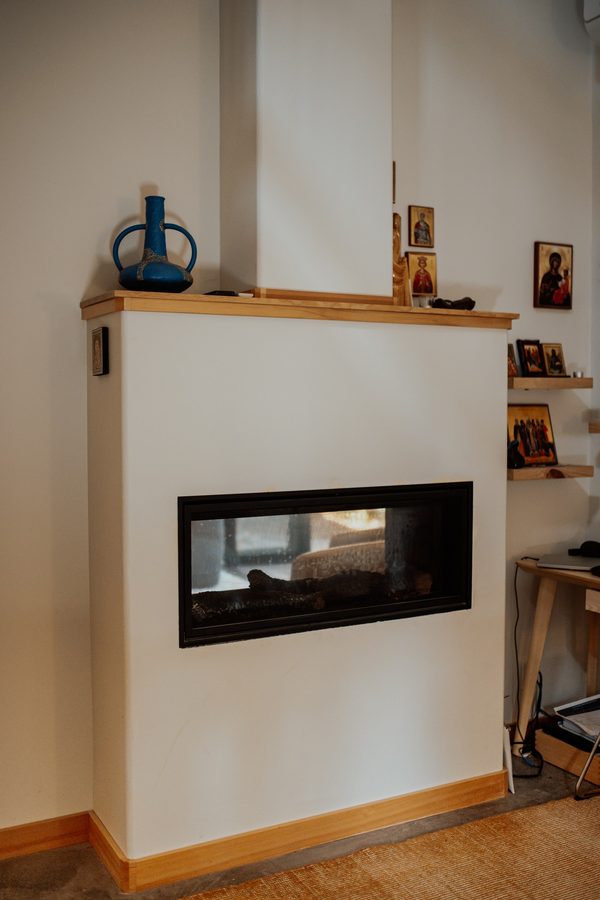 Bedroom side of the two-sided fireplace with a wood mantel