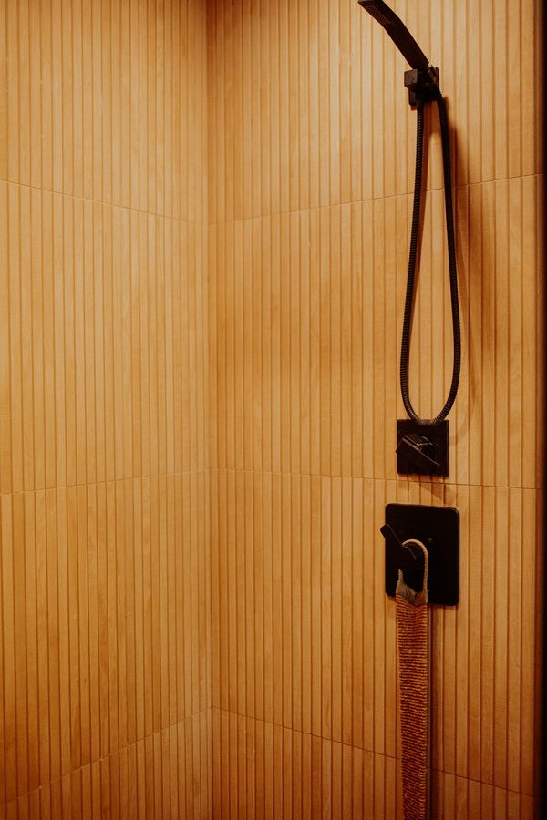 Dark shower fittings against vertically textured wall tile